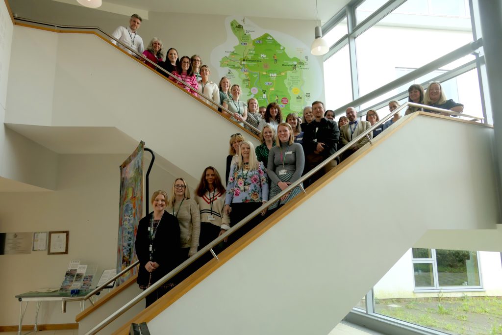 approx 30 people on a staircase, the AET training team